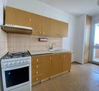 A kitchen in a 3-room apartment with a gas stove and light-colored furniture.