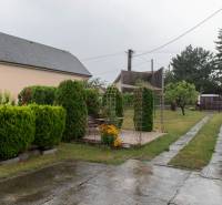 The garden of a family house in Rovinka with a walkway, greenery, and a gazebo.