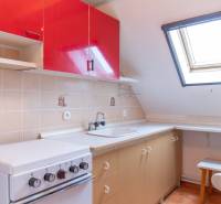 A kitchen with red cabinets, a skylight, and a stove in a family house.