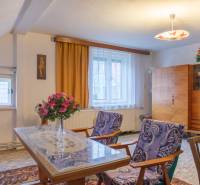 Living room in a family house with flowers, furniture, and artwork on the wall.