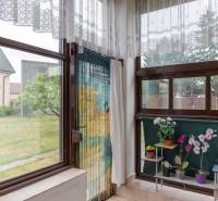 The interior of a family house with access to the yard, decorated with flowers on the windowsill.