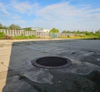 Concrete surface with a manhole cover in the area of Warehouses and Halls, Košice - Šaca district.