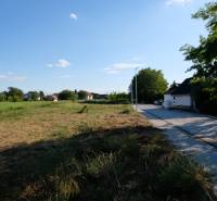 Plots - housing in Malinovo with a road next to the development and surrounding greenery.