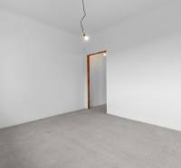 Empty room with white walls and a concrete floor in a family house.