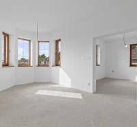 A spacious room with multiple windows in a family house, equipped with sockets.