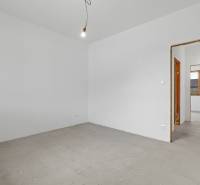 Interior of a room in a family house with white walls and a concrete floor.
