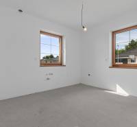 Empty room in a family house with a concrete floor and wooden windows.