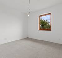 An empty room in a family house with a window and a simple light bulb on the ceiling.