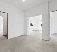 Spacious interior of a family house with white walls and concrete floor.