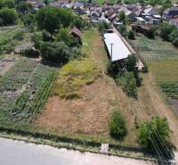 Landscape in Štrkovec with fields, buildings, and trees; natural parts of house construction.
