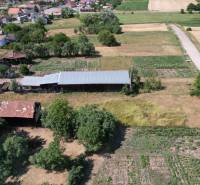 Rural house construction in Štrkovec with agricultural land, trees, and a road in the vicinity.