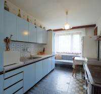 A kitchen with blue cabinets and patterned tiles in a family house.