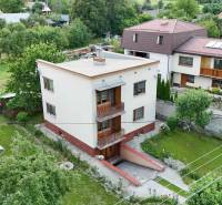 A family house in Dolná Mariková surrounded by greenery and neighboring houses in a peaceful environment.