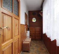 Interior of a family house with wooden doors and a glazed interior with decorative curtains.
