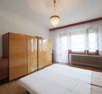 A bedroom with wooden furniture and a chandelier in a family house, a bright room.