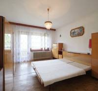 Bedroom in a family house with wooden furniture and a chandelier.