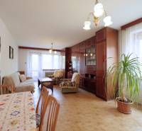 Living room in a family house with a carpeted floral table and wooden furniture.