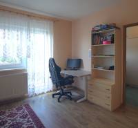 A workspace in a family house with a desk, chair, and shelf.