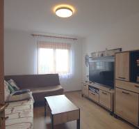 Living room with a sofa, TV, and furniture in a family house.