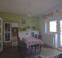 Dining room in a family house with a table, chairs, and a cabinet with decorations.