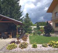 The garden of a family house on Športová Street in Brodské, with a gazebo and flower beds.