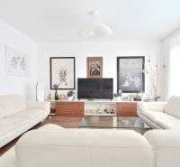 Bright living room with paintings, sofas, and a television in a 4-room apartment.