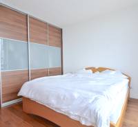 Bedroom with a large built-in wardrobe and bed in a 4-room apartment.