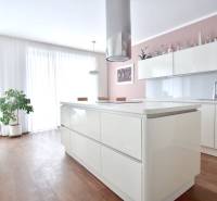 A bright kitchen with an island in a 4-room apartment with built-in cabinets and wooden flooring.