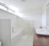 Bathroom in a 4-room apartment with a bathtub, sink, large mirror, and window.