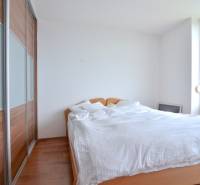 Bedroom in a 4-room apartment with a bed, built-in wardrobe, and a large window.