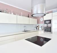 A kitchen in a 4-room apartment with white cabinets and built-in appliances.