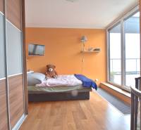 A room with orange walls, a bed, a wardrobe, and a bed in a 4-room apartment.