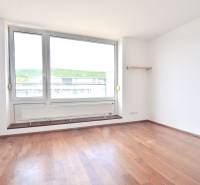 An empty room with a large window and wooden floor in a 4-room apartment.