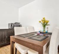 Dining area with a table and chairs in a 3-room apartment, a vase with flowers on the table.