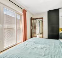 Bedroom in a 3-room apartment with a wardrobe, windows, and curtains.