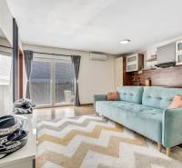 Living room in a 3-room apartment with a sofa and access to the terrace.