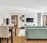 Living room in a 3-room apartment with a sofa, dining table, and a TV on the wall.
