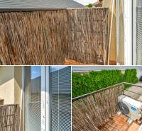 Balcony of a 3-room apartment with reed covering, air conditioning, and a view of the courtyards.