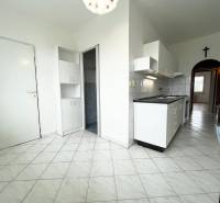 A kitchen with white cabinets and tiles in a 2-room apartment, a bright and spacious area.