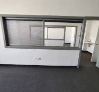 An office interior with a glass partition and a sink in the background.