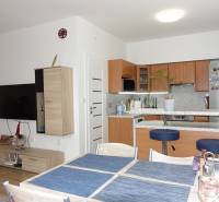 Kitchen and living room in a 3-room apartment, furnished interior with wooden furniture.