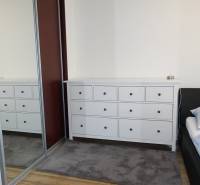 A room with a chest of drawers, a bed, and a mirrored wardrobe in a 3-room apartment.