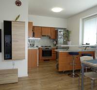 A kitchen with a bar counter and a dining table in a 3-room apartment.