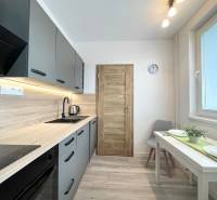 A modern kitchen in a studio apartment with wooden and metal elements, equipped with appliances.