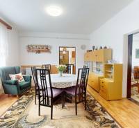 Dining room in a family house with a floral carpet and a dining table.