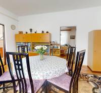 Dining room in a family house with a round table, chairs, and a display cabinet.
