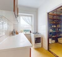 A kitchen with a gas stove and an adjoining pantry in a family house.
