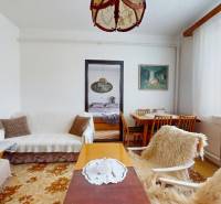 Living room of a family house with seating, a dining table, and decorations on the walls.