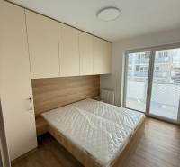 Bedroom in a 3-room apartment with a bed, wardrobe, and large window.