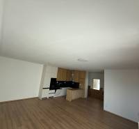 Bright open space with a kitchen and wooden floor in a 3-room apartment.